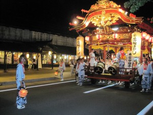 夜の関善賑わい屋敷の前を行く豪華な山車